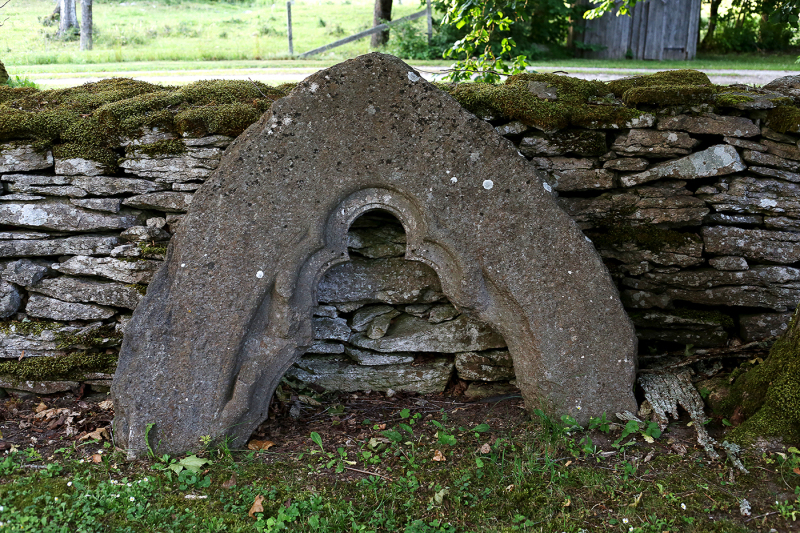 Överstycke av grå kalksten till gotiskt fönster från 1300-talet i långhusets södra mur, avlägsnat på 1860-talet.