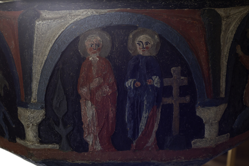 Ett dubbelkors och två personer med helgongloria; möjligen den romerske kejsaren Konstantin den store och hans mor Helena, som återfann Kristi kors på Golgata vid en vallfärd till Jerusalem år 324
